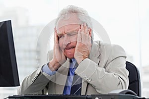 Upset senior manager working with a monitor