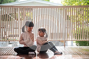 Upset siblings ignoring each other at home