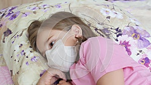 Upset sick child girl lying on a bed