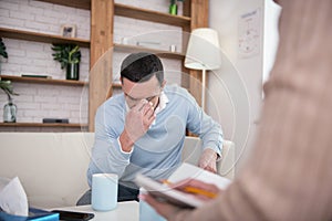 Upset sorrowful man demonstrating his mournfulness