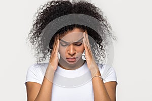 Upset stressed black woman massaging temples feeling pain terrible migraine