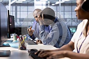 Upset technician doing face palm gesture, failing to optimize server farm photo