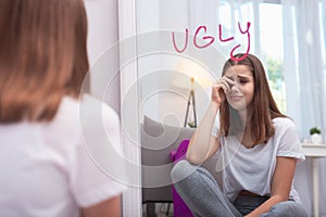 Upset teen girl believing in her ugliness