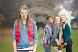 Upset Teenage Girl With Friends Gossiping photo