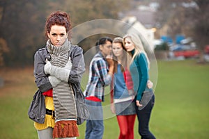 Upset Teenage Girl With Friends Gossiping