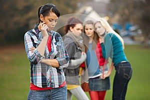 Upset Teenage Girl With Friends Gossiping