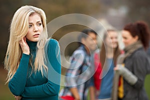 Upset Teenage Girl With Friends Gossiping