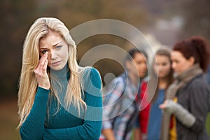 Upset Teenage Girl With Friends Gossiping