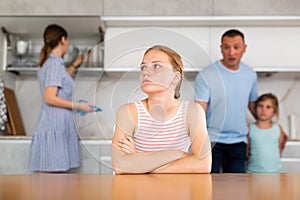 Upset teenage girl listening to discontented father reprimand