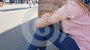 Upset teenage girl sitting on sidewalk, loneliness, adolescent transition