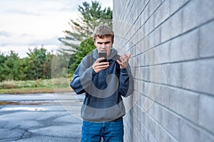 Upset teenager looking at his cellphone.