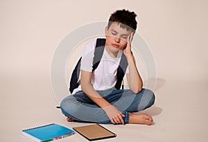 Upset teenager, school boy, holding head, demotivated , feeling difficulties with learning and problems at school