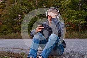 Upset teenager sitting on the ground.