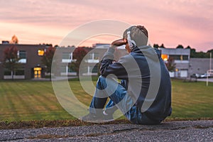 Upset teenager sitting on the ground.