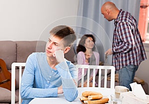 Upset teenager suffering from mom and dad arguing