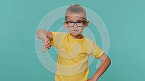 Upset toddler children boy showing thumbs down sign, expressing discontent, disapproval, dislike