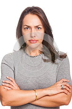 Upset unsatisfied woman standing with arms folded and looking at camera isolated