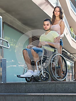 Upset wife with man in wheelchair on stairs