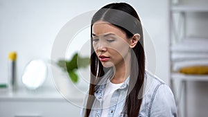 Upset woman in bathroom looking down, ashamed with female health problems