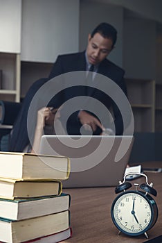 Upset woman being scolded by boss for working at office and Boss point to clock showing time for deadline job