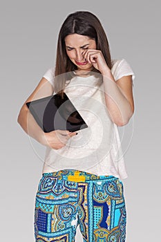 Upset woman with broken tablet
