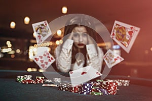 Upset woman in casino with falling cards