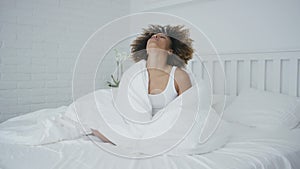 Upset woman cuddling in bed