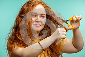 Upset and woman with her damaged dry hair face expression blue background