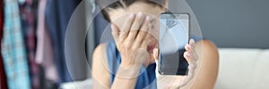 Upset woman holding a broken smartphone closeup