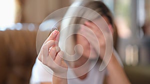 Upset woman holding engagement ring and thinking about dissolution of marriage or divorce