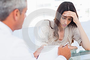 Upset woman listening to her docter talking about a illness