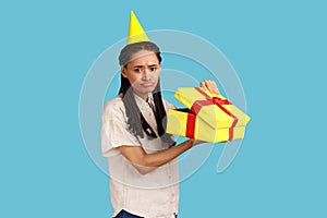 Upset woman looking into gift box, opening present and looking at camera with sadness.