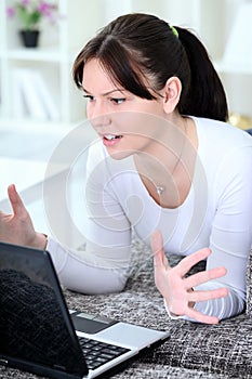 Upset woman looking in laptop