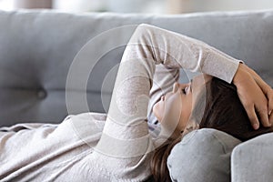 Upset woman lying on couch suffer from problems