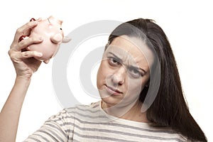 Upset woman with a piggy bank