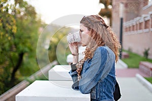 Upset woman planning revenge while drinking in park