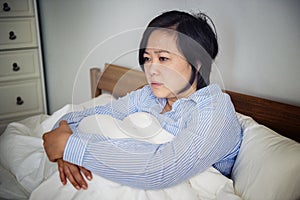 An upset woman pondering in bed