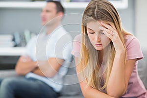 Upset woman thinking on couch after fight with husband