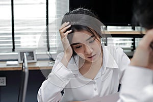 Upset young Asian business woman suffering from severe problem between meeting in office