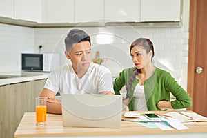 Upset young couple with financial bills having conflict at home