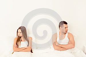 Upset young couple having marital problems or a disagreement in bed
