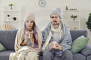 Upset young couple having problem with central heating or suffering from cold or flu