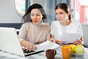 Worried LGBT couple working with papers