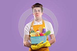 Upset young guy with cleaning supplies