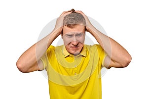 Upset young male in yellow T-shirt clutched at head, forgetful man, isolated on white background