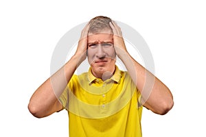 Upset young male in yellow T-shirt clutched at head, forgetful man, isolated on white background