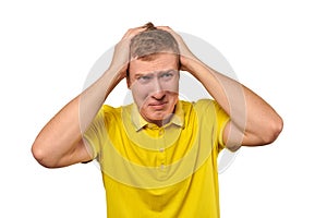 Upset young male in yellow T-shirt clutched at head, forgetful man, isolated on white background