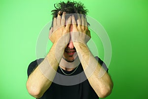 Upset young man on a light green wall background. Emotion of chagrin