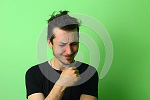 Upset young man on a light green wall background. Emotion of chagrin