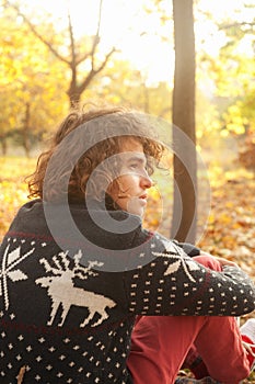 Upset young man resting in autumn park